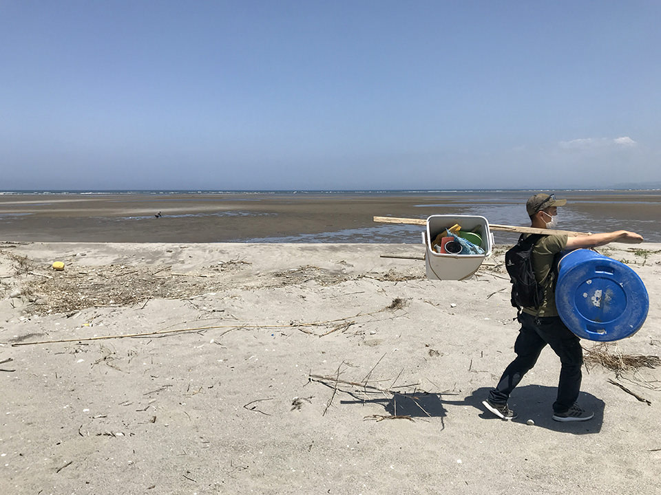 海岸で拾った全てを天秤棒で運ぶ